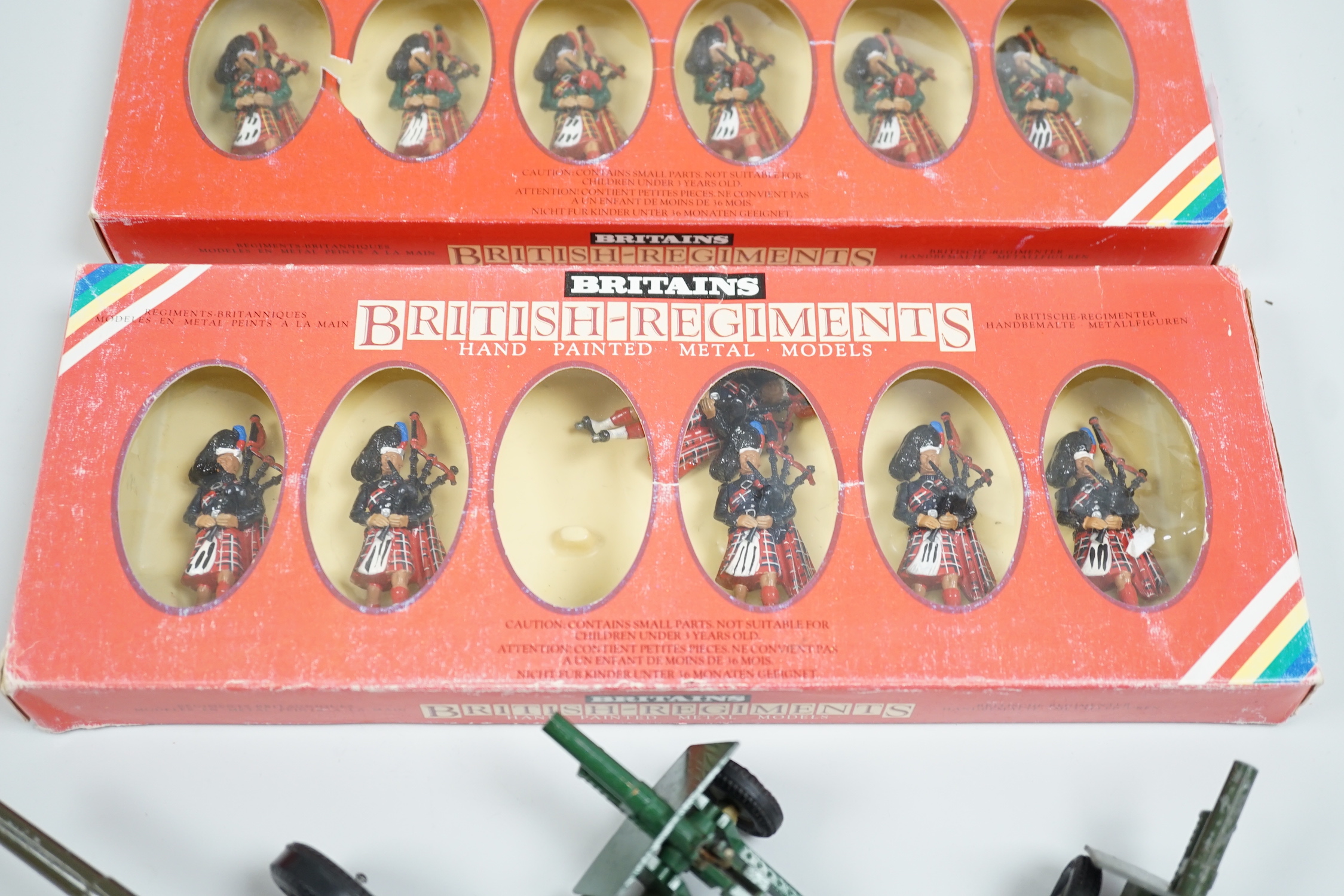 Two Britains model cannons, a Crescent Toys cannon and two sets of Britains British Regiment figures, Black Watch and Scots Guards